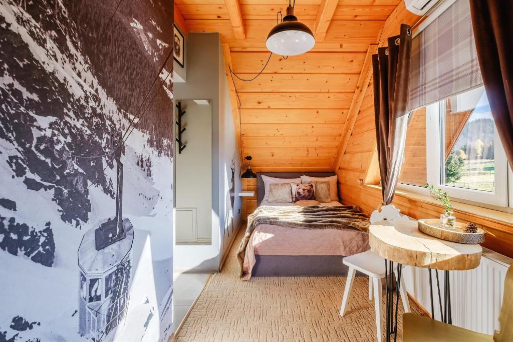 ポロニンにあるWilla Klimek Jacuzzi&Saunaのログキャビン内のベッドルーム(ベッド1台、窓付)