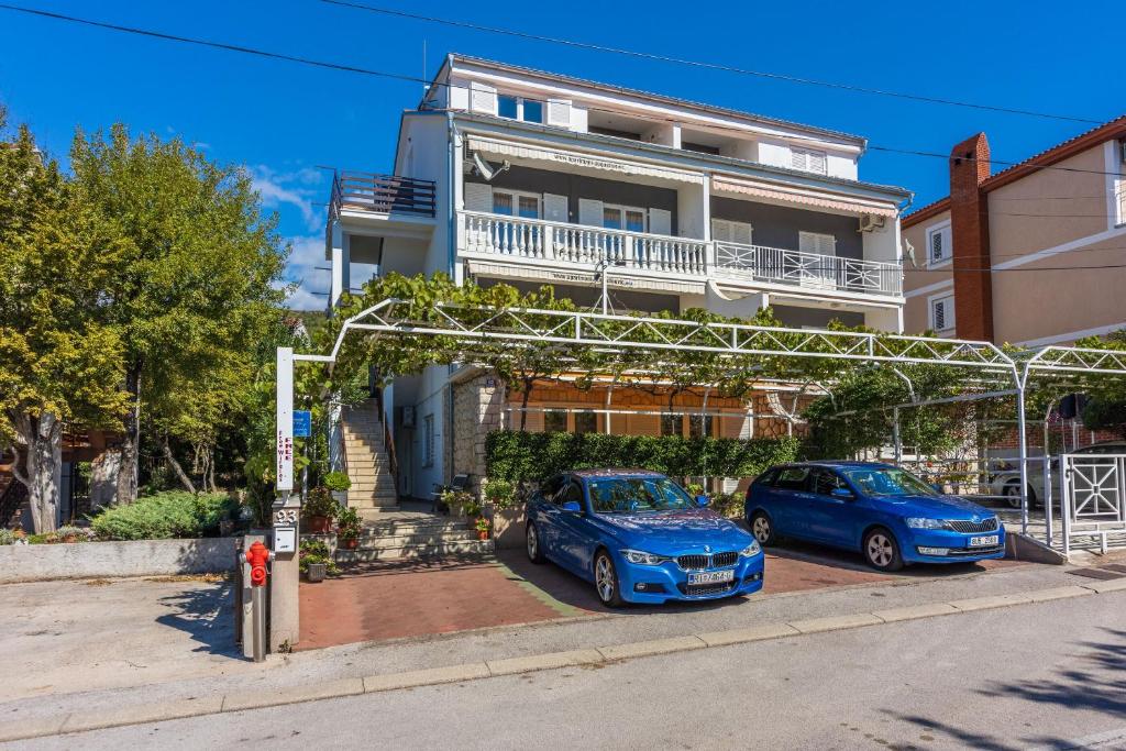 two cars parked in front of a house at Apartments PERA in Selce
