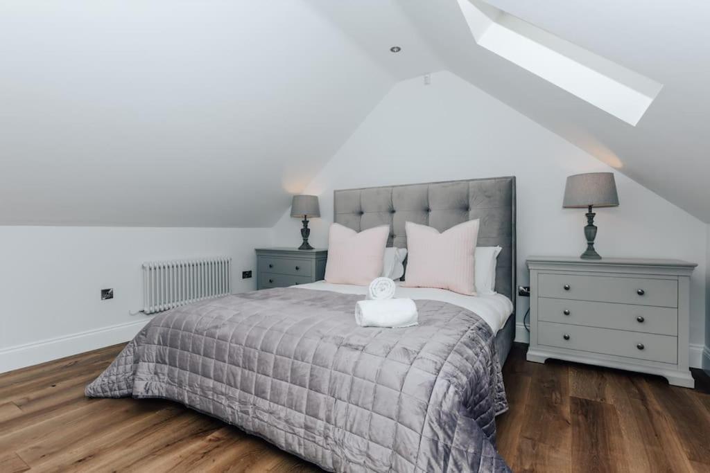 a bedroom with a large bed with pink pillows at The Woodpecker - 1 Bedroom Annexe in Harpsden