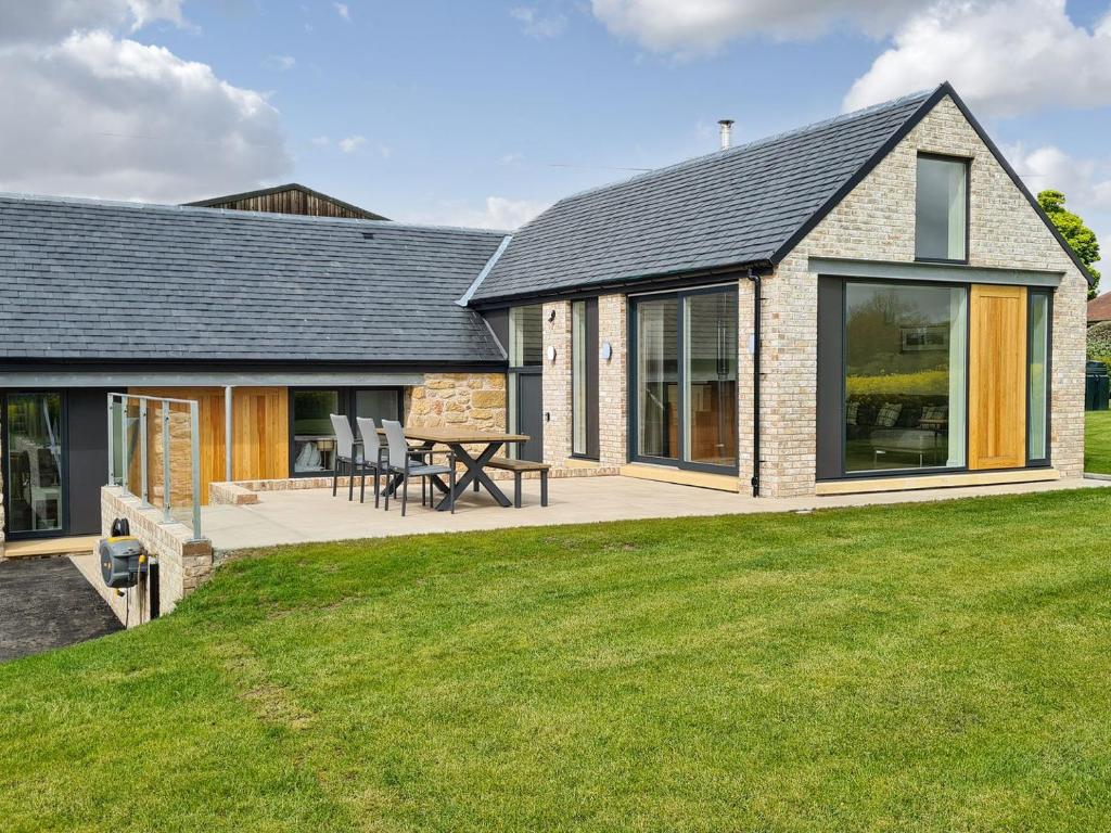an extension to a house with a patio and grass at Falcon Cottage in Linlithgow
