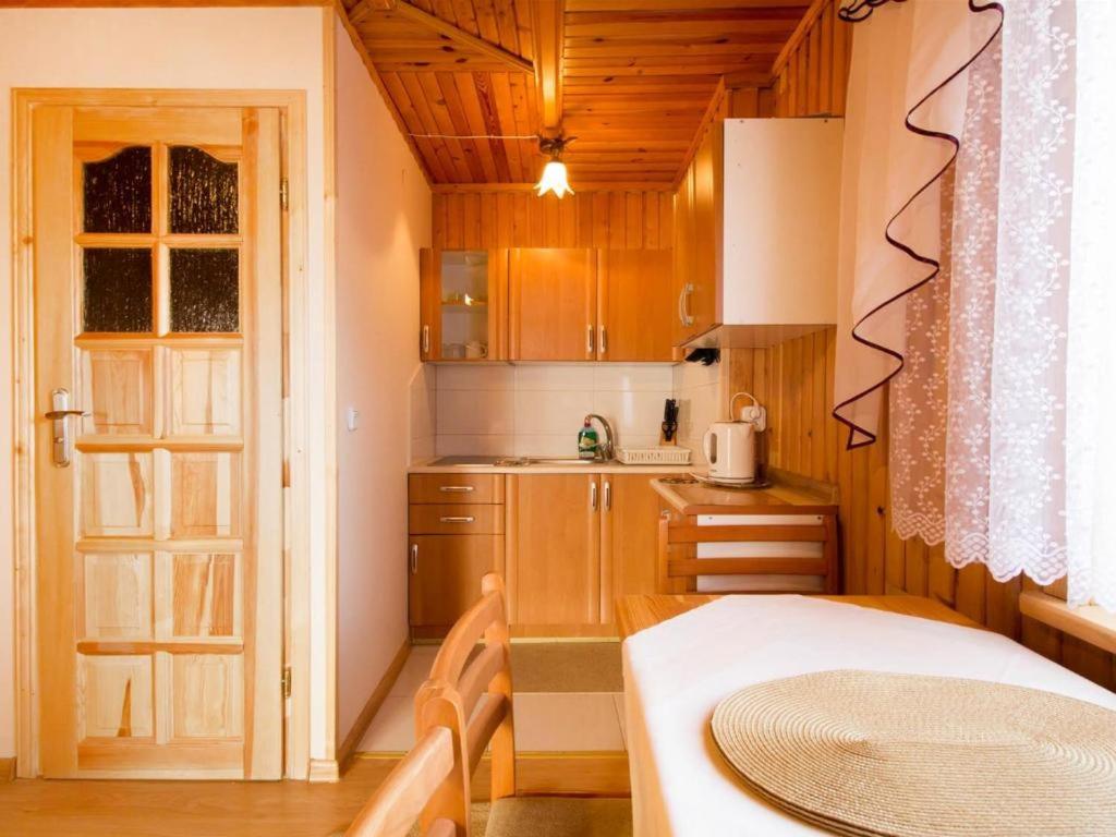 a kitchen with wooden cabinets and a table in a room at Apartamenty i pokoje Borysek in Białka Tatrzanska