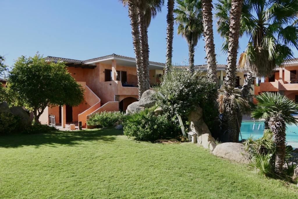 a house with palm trees and a swimming pool at Residence con piscina a Palau, a soli 150 mt. dal mare in Palau