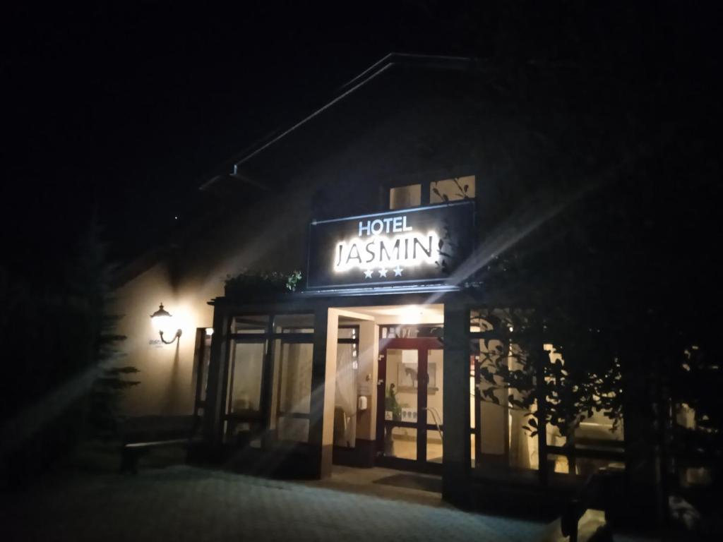a sign for a hotel restaurant at night at Hotel Jaśmin 