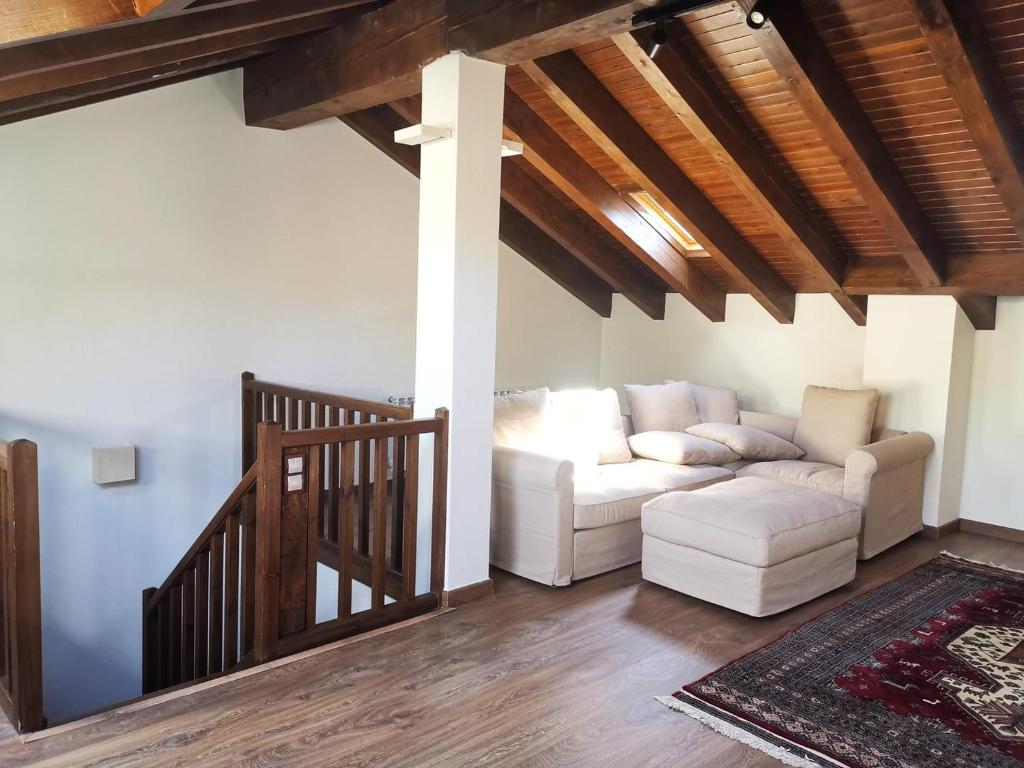 sala de estar con sofá blanco y escalera en Casa adosada en Guils, en Guils de Cerdaña
