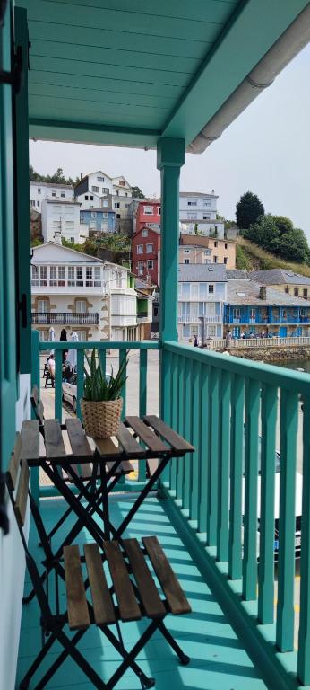 a picnic table on a balcony with a view of a town at El balcón de Carmen in O Barqueiro
