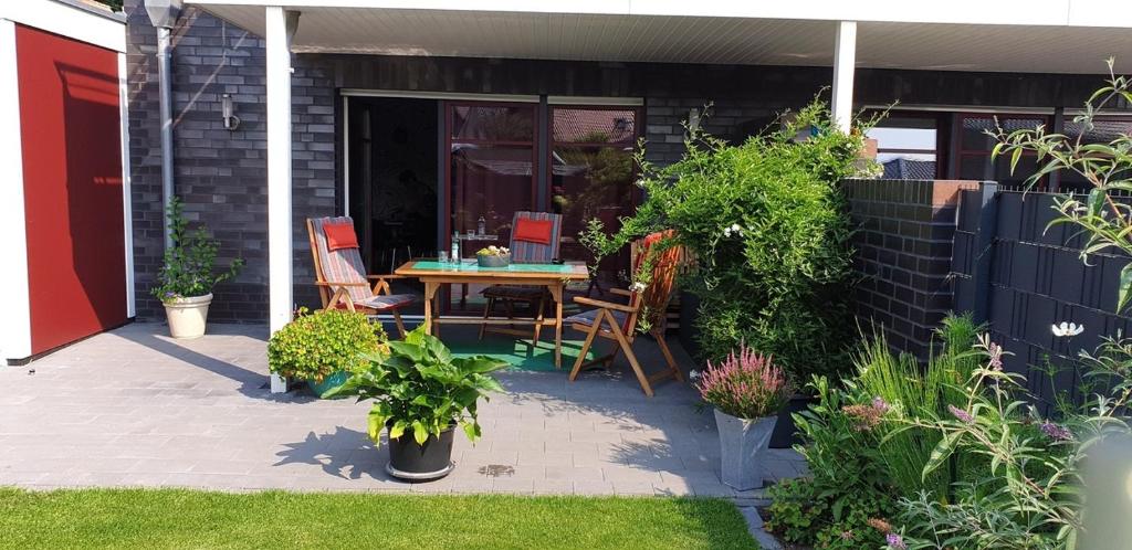 un patio con mesa, sillas y plantas en Lemke-Ferienwohnung en Nordhorn