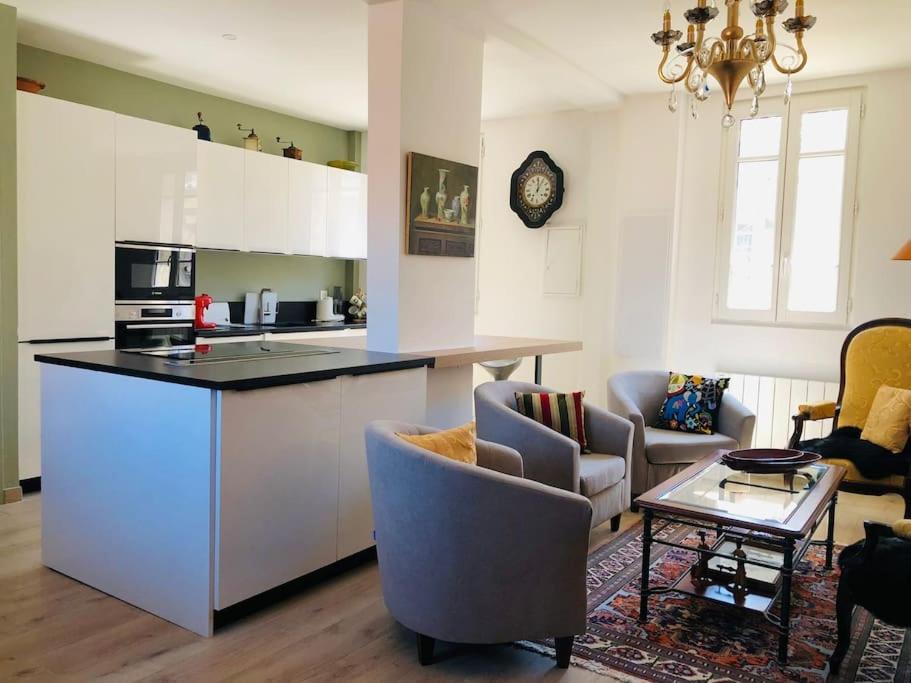 een keuken en een woonkamer met een aanrecht en stoelen bij Appartement Standing Hôtel Particulier Montpellier in Montpellier