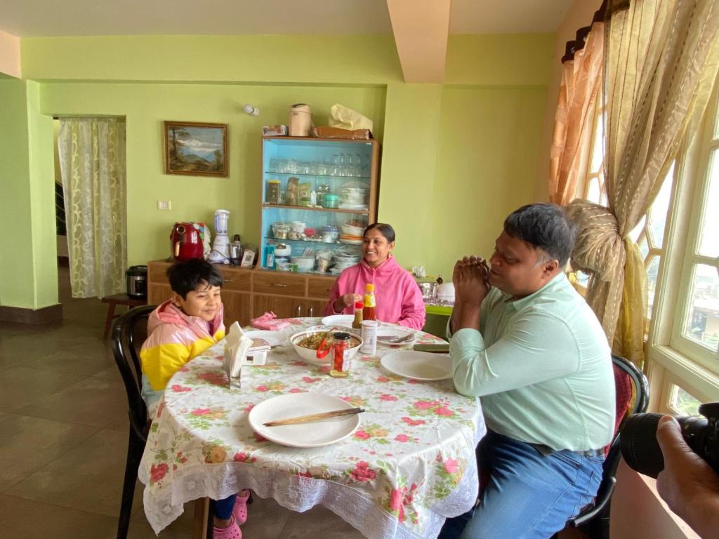 grupa ludzi siedzących przy stole w obiekcie Syangden Villa, Nagbeli BNB w mieście Dardżyling