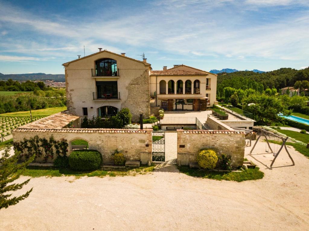 una casa vieja con una valla delante de ella en Can Alemany, en Santa Maragarida de Montbui