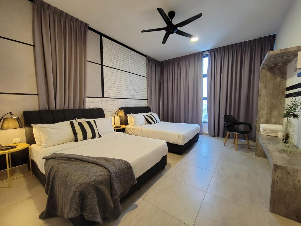 sypialnia z 2 łóżkami i wentylatorem sufitowym w obiekcie Atlantis Residences By 360 HOME w Malakce