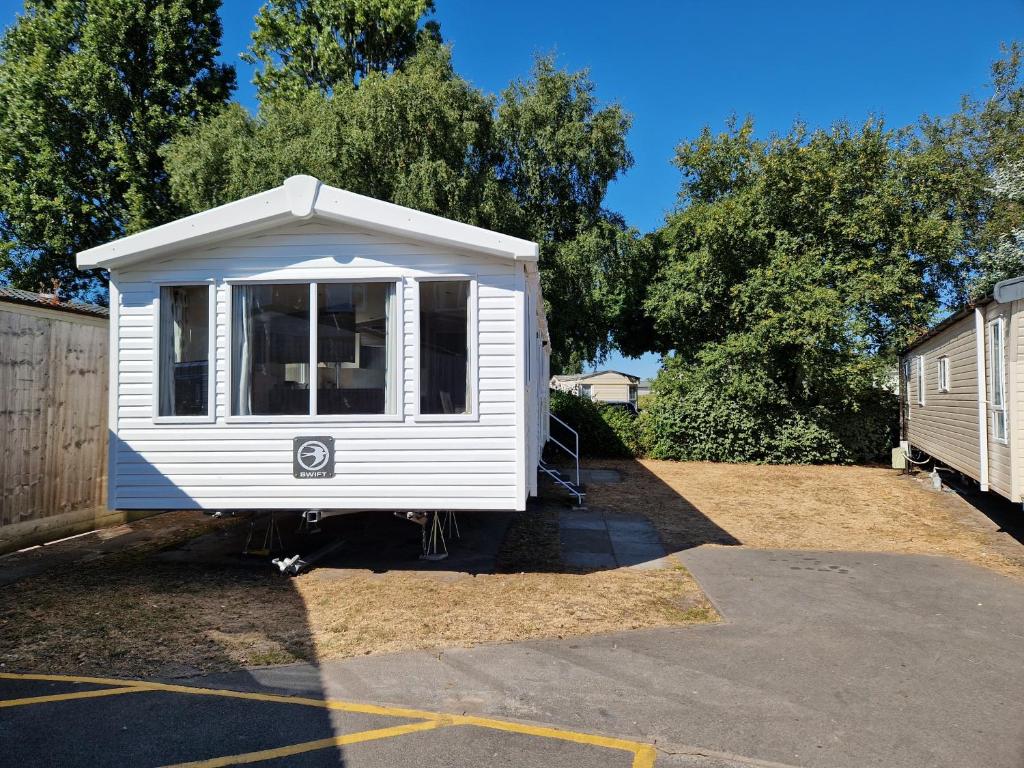 a white tiny house sitting in a parking lot at Beautiful 3-Bed Caravan at Rockley Park Poole in Poole