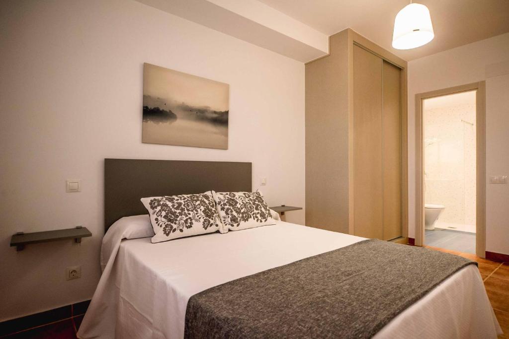 1 dormitorio con cama con almohada en Apartamentos AL PASO DE TOLEDO, Puy du Fou a 10km, en Burguillos de Toledo