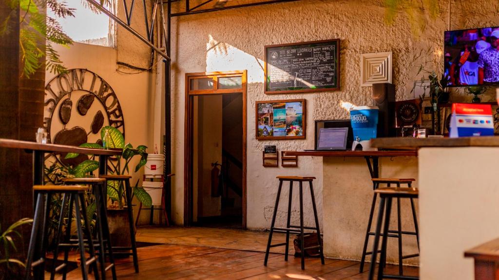 un bar con taburetes frente a una habitación en The Slow Leopard, en Dar es Salaam
