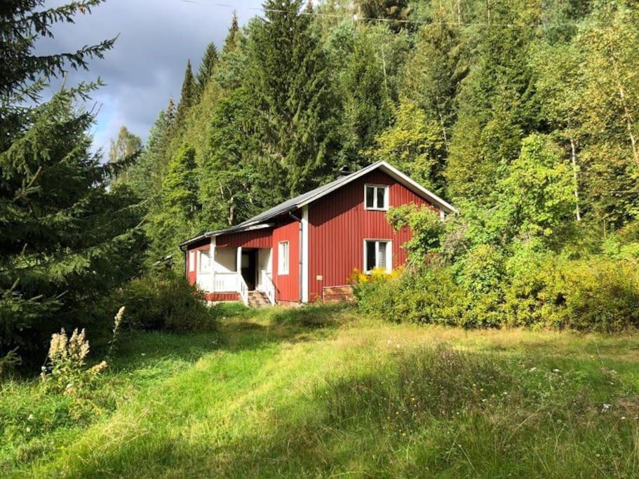 un granero rojo en medio de un campo en Little Forest House "Our Little Farm" en Ekshärad
