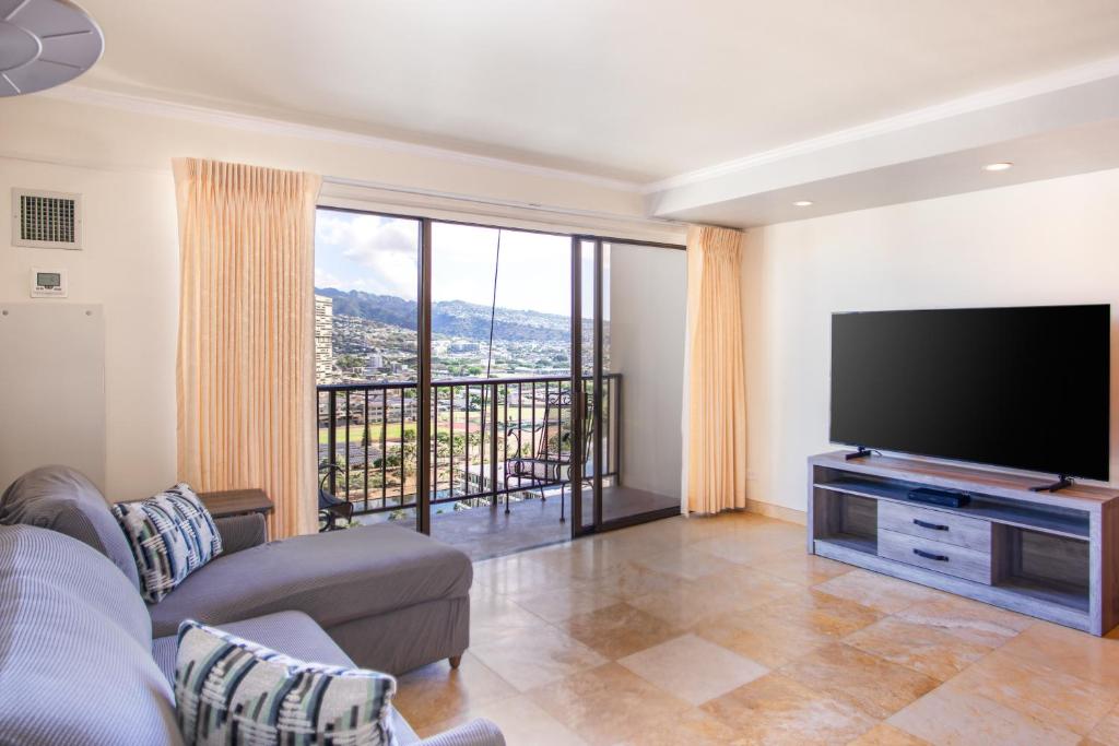 a living room with a large flat screen tv at Four Paddle Condominium 2210 Thirty plus night rental in Honolulu