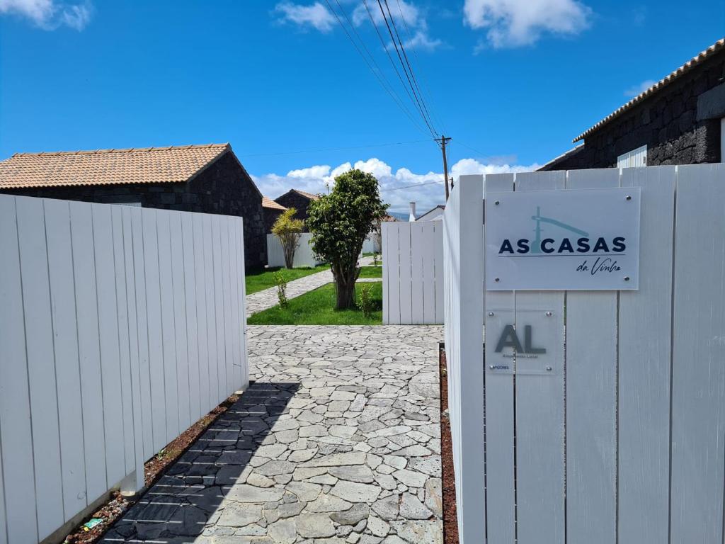 een wit hek en een hek met een bord erop bij As Casas da Vinha in Criação Velha