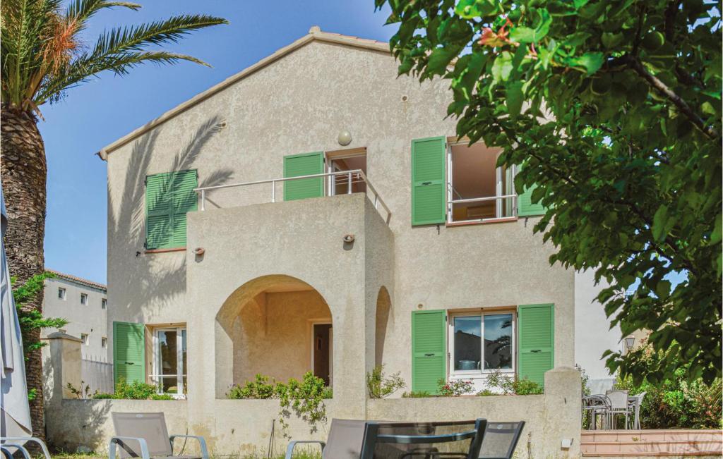 uma casa com persianas verdes e uma palmeira em Cozy Home In Algajola With Kitchen em Algajola