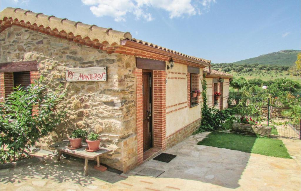 Una casa de piedra con un cartel en el costado. en Cozy Home In Aldeanue, De La Sierra With Kitchen, en Aldeanueva de la Sierra
