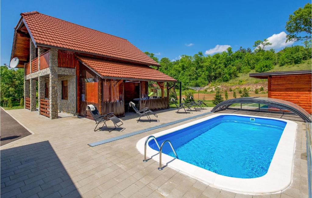 uma piscina em frente a uma casa em Cozy Home In Perusic With Jacuzzi em Perušić
