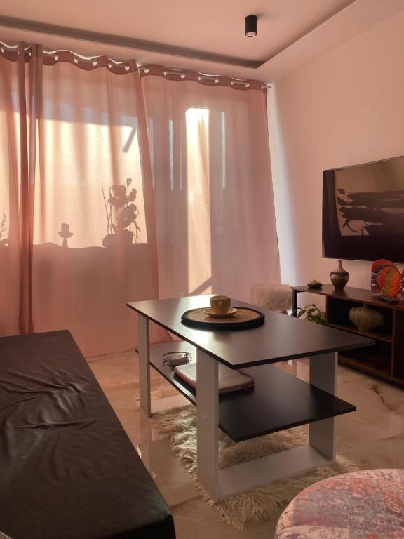uma sala de estar com uma mesa de centro e uma televisão em Apartament z balkonem i widokiem na morze w Sopocie blisko Opery Leśnej em Sopot