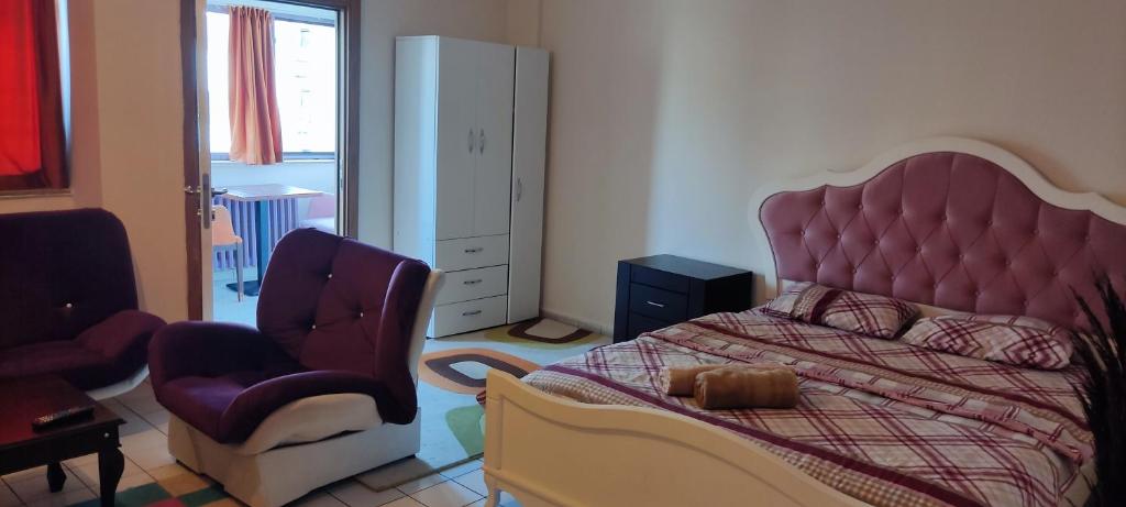 1 dormitorio con 1 cama grande y 1 silla en Han konaklama en Ankara