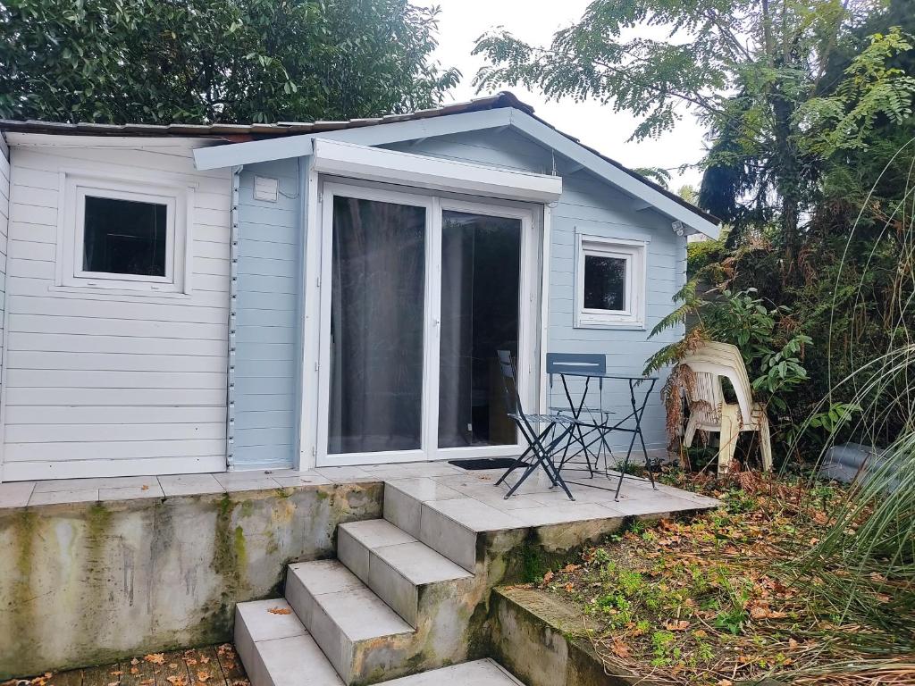 een klein huis met een veranda en een trap bij Chalet Aurore in Mérignac