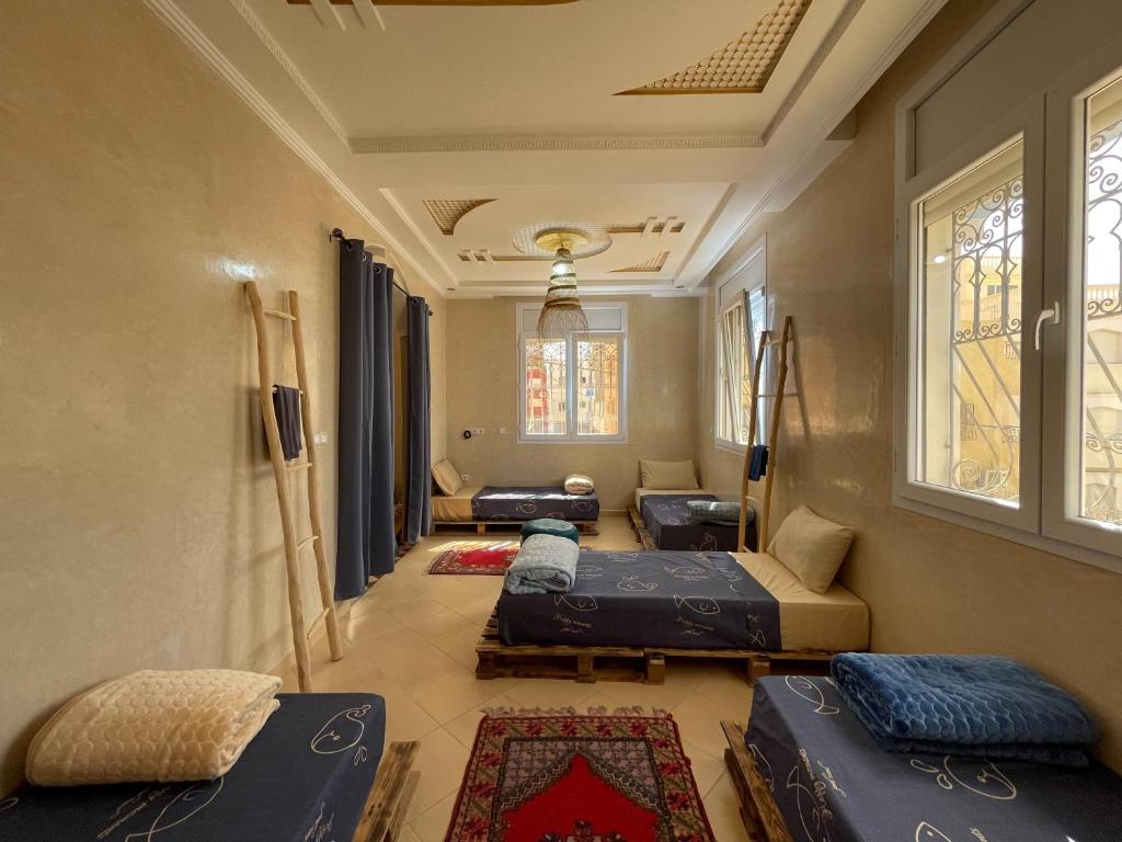 Pokój z 3 łóżkami, kanapą i oknami w obiekcie Fleur de cactus, Guesthouse, Tamraght w mieście Agadir