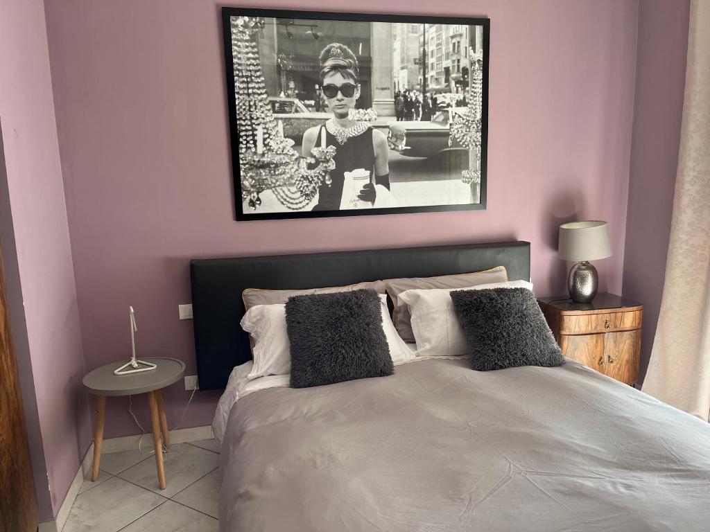 a bedroom with a bed with a picture on the wall at Via Roma suite in Ortona