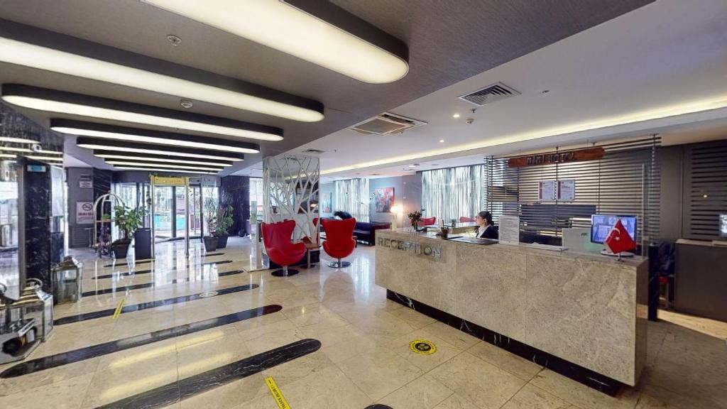 a lobby with red chairs and a reception desk at Mimi Hotel Ankara in Ankara