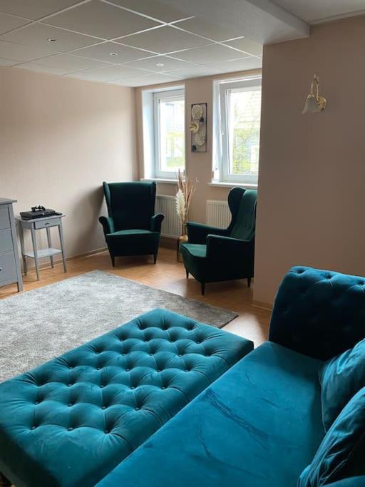 - un salon avec un canapé bleu et des chaises dans l'établissement Residence Da Thea, à Clausthal-Zellerfeld