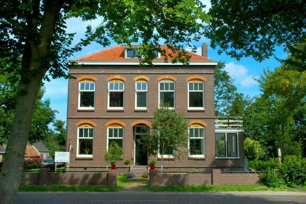 a large brick building with an orange roof at B&B De Postoari Terschelling in Hoorn