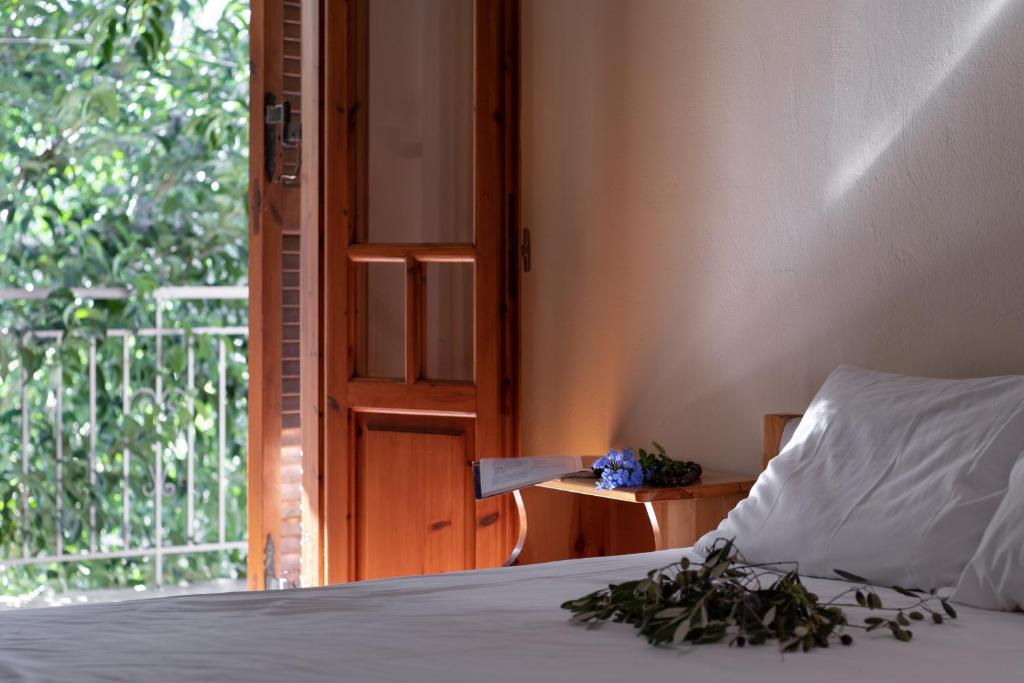 KharadhiátikaにあるKrinos apartment 2の白い枕が置かれたベッドとバルコニー付きの窓