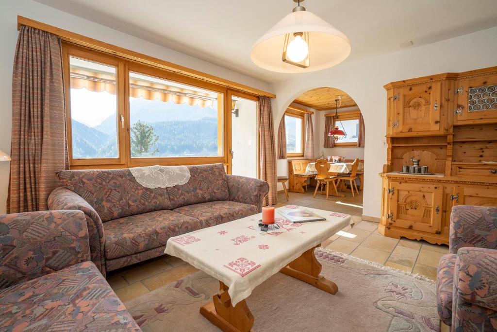 a living room with a couch and a table at Chasa Nalains in Scuol