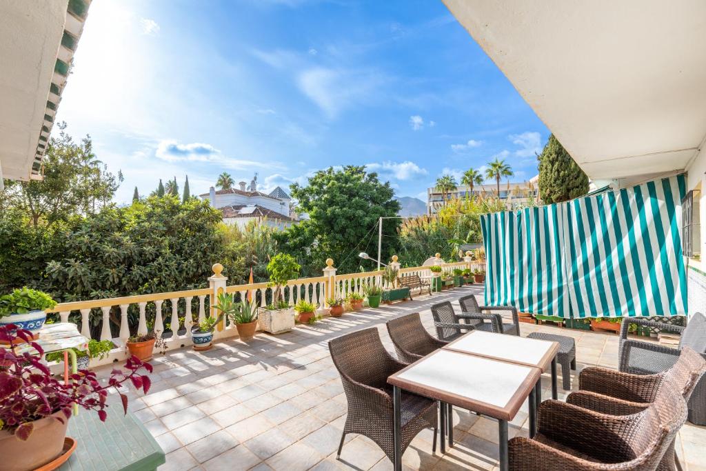 d'une terrasse avec des chaises, des tables et une clôture. dans l'établissement 4 bedr groundfl apartm 60m beach, à Torremolinos