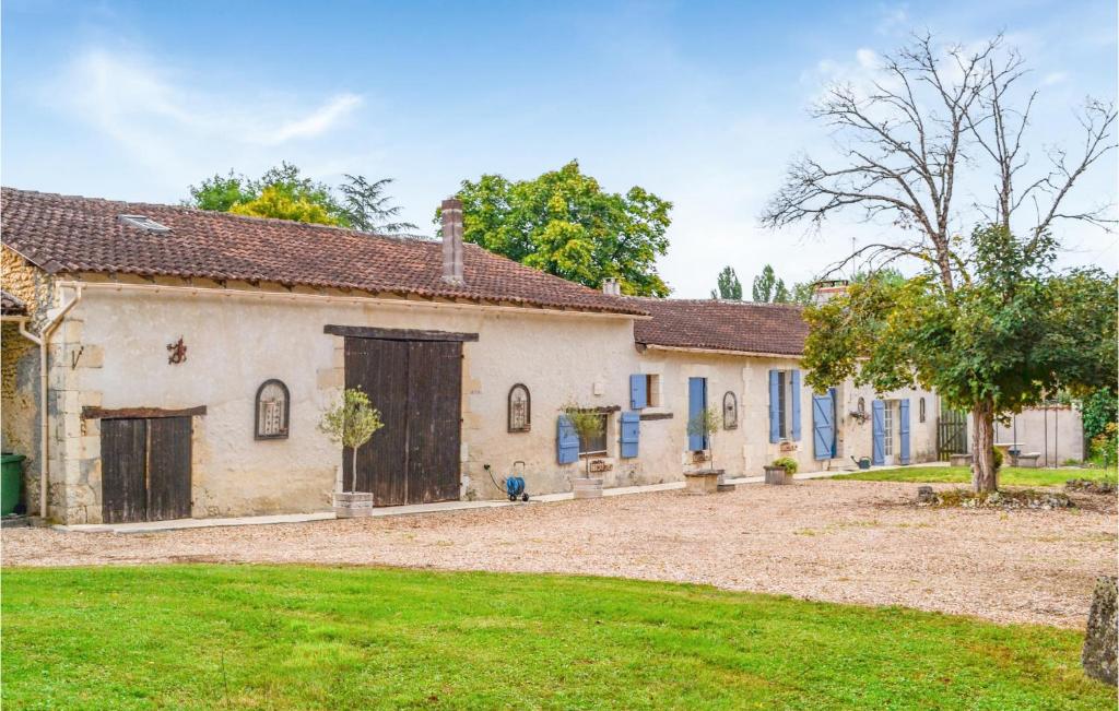 une maison ancienne avec des portes bleues et une cour dans l'établissement Nice Home In Bourg Du Bost With Wifi, à Bourg-du-Bost