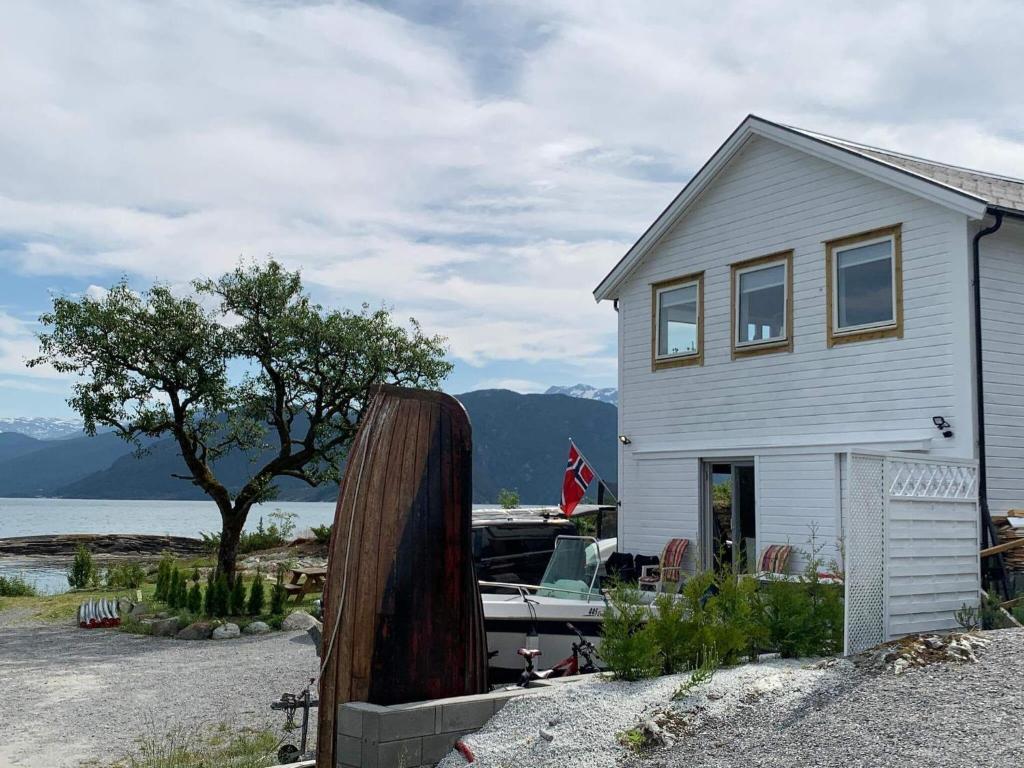 uma casa com um barco estacionado em frente em Holiday home TØRRVIKBYGD II em Tyrvikbygd