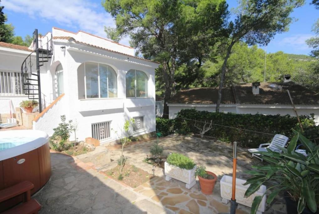 una casa blanca con un patio con plantas en Villa Las Hiertas - 6-8 personnes - vue mer en Alcocéber