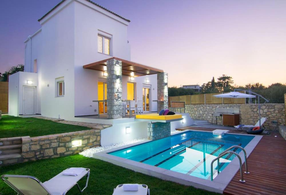 a swimming pool in the backyard of a house at Villa Aada - moderne Komfortvilla mit eigenem Pool in Loutra