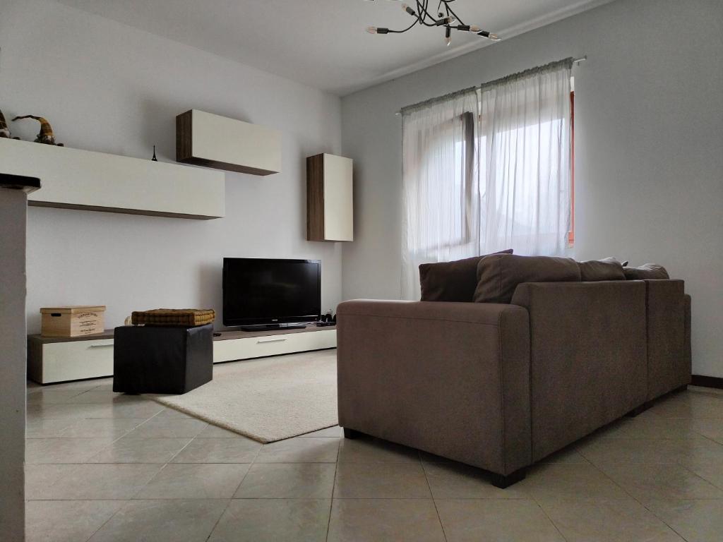 salon z brązową kanapą i telewizorem w obiekcie MANZONI APARTS - SUITE Superior w mieście San Pellegrino Terme
