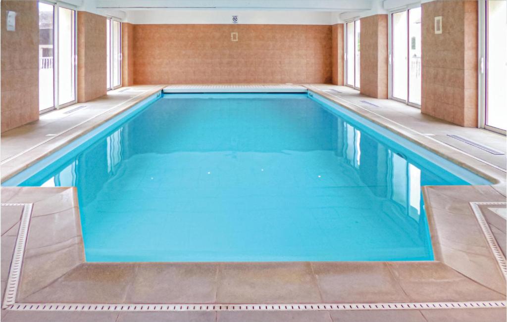 a large swimming pool with blue water in a building at Lovely Home In Vaudoy-En-Brie With Wifi in Vaudoy-en-Brie