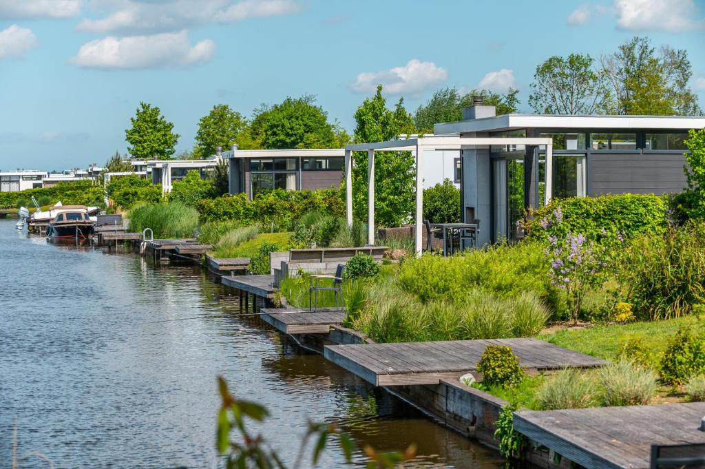 a building next to a river with a dock at EuroParcs Veluwemeer in Nunspeet