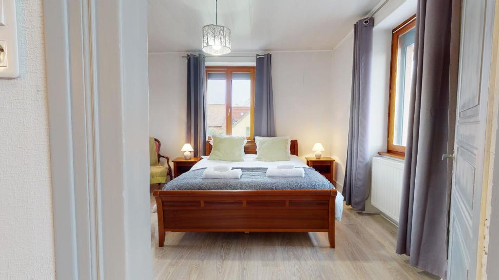 a bedroom with a bed and a window at La maison Blanche - Issenheim in Issenheim