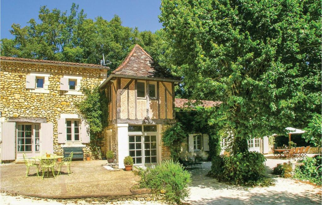 Saint-Martin-des-CombesにあるBeautiful Home In St, Martin Des Combes With 5 Bedrooms, Outdoor Swimming Pool And Wifiの庭にテーブルと椅子を配置した石造りの家