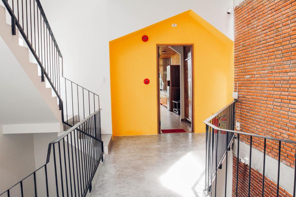 a hallway with stairs and a yellow wall at Anstay Homestay & Apartment in Da Nang