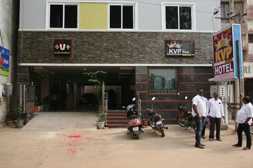 un grupo de personas parados fuera de un edificio en KVP Inn en Tirupati
