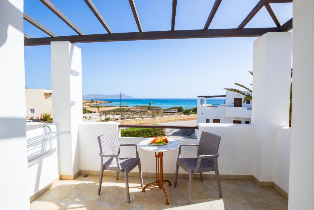 a balcony with a table and chairs and a view of the ocean at Irini Hotel in Afiartis