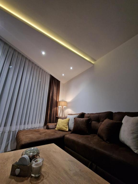 una sala de estar con un sofá y una mesa en Garnet Star Apartments 1, en Kopaonik