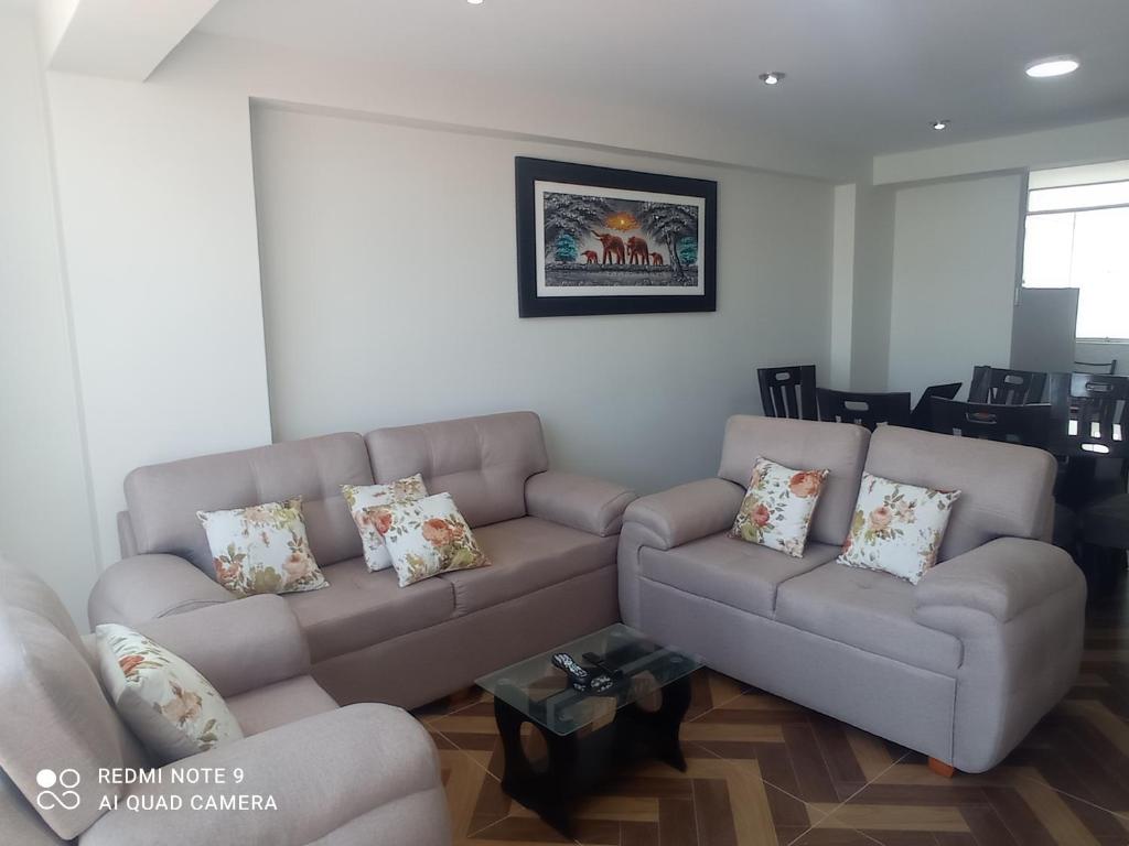 a living room with a couch and a table at RESIDENCIAL QUIÑONES in Cusco