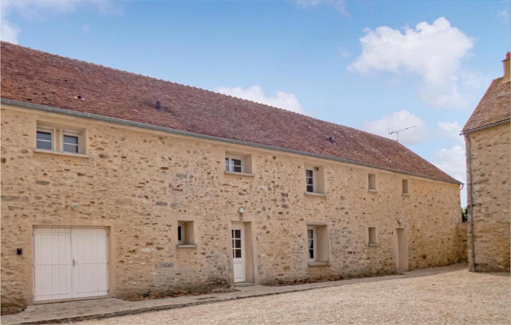 un gran edificio de ladrillo con garaje blanco en Gorgeous Home In Vaudoy-en-brie With Wifi, en Vaudoy-en-Brie