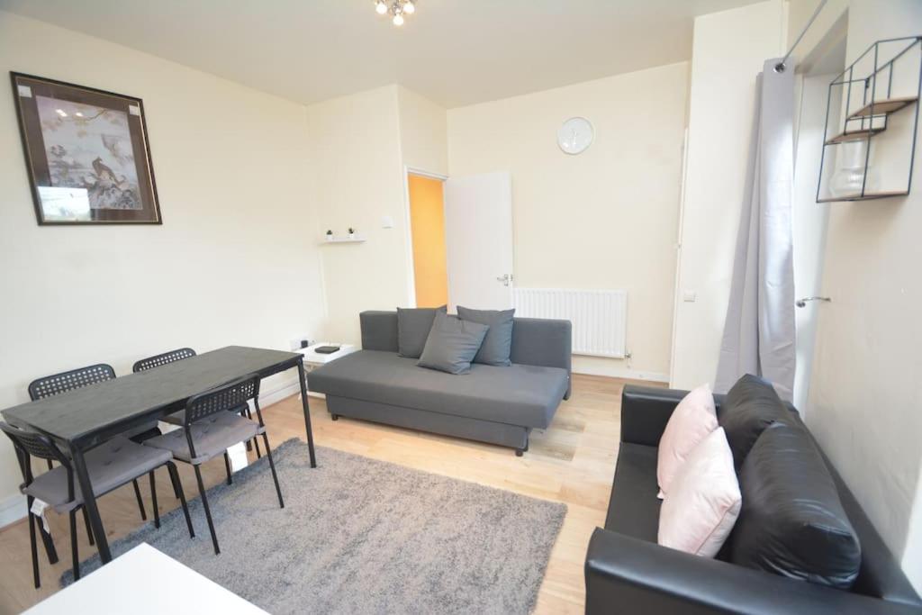 ein Wohnzimmer mit einem Sofa und einem Tisch in der Unterkunft Lovely 4 bedroom apartment close to the city walking distance from the rivere view in London